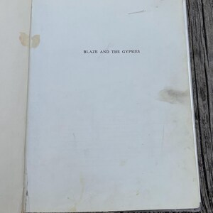 May include: The title page of a book with the text BLAZE AND THE GYPSIES printed in black ink in the center. The off-white paper shows visible signs of age, including light brown staining and discoloration spots along the left and right edges.