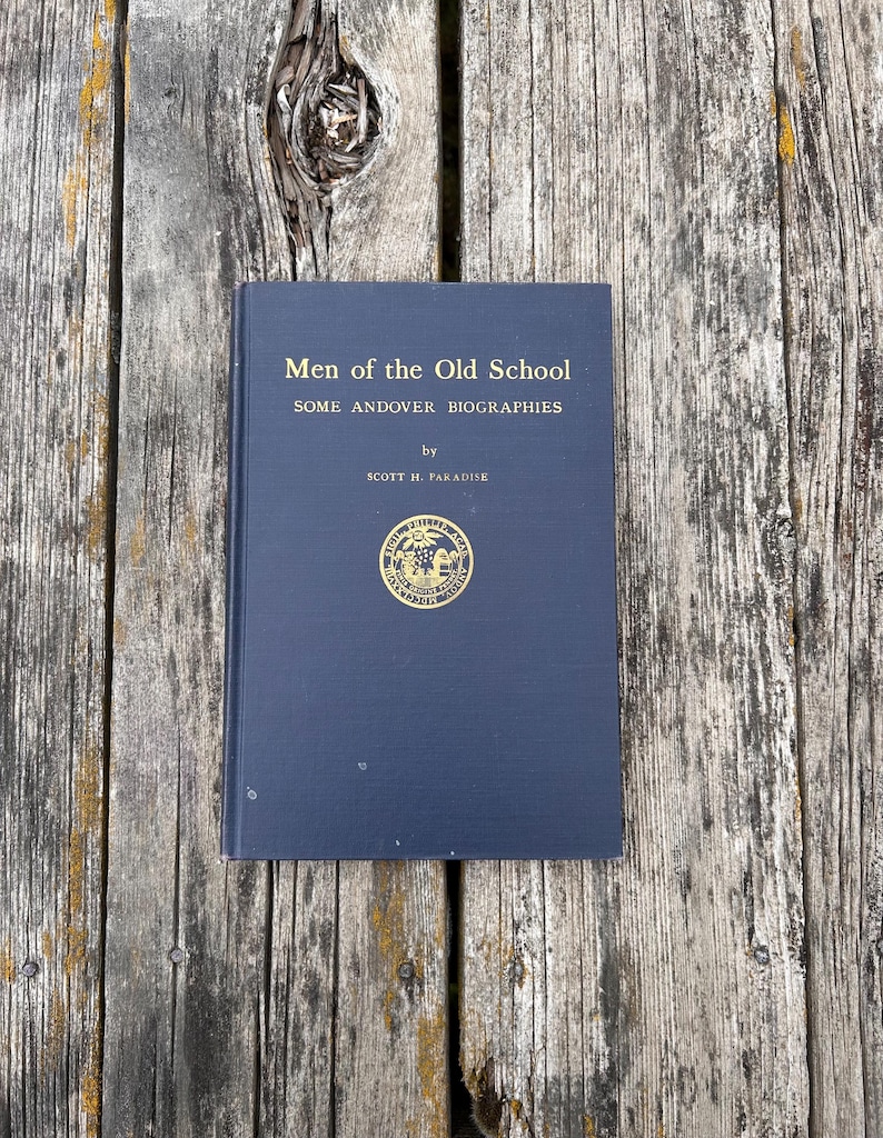 Może przedstawiać: Ciemnoniebieska książka w twardej oprawie zatytułowana Men of the Old School: Some Andover Biographies autorstwa Scotta H. Paradise'a. Na przedniej okładce znajdują się złote napisy oraz okrągły złoty emblemat z pieczęcią pośrodku.