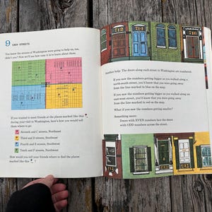 May include: An open book page titled 9 Easy Streets featuring a colourful map divided into four quadrants, illustrations of numbered house doors, and instructional text explaining the grid system of Washington streets with numbered locations.
