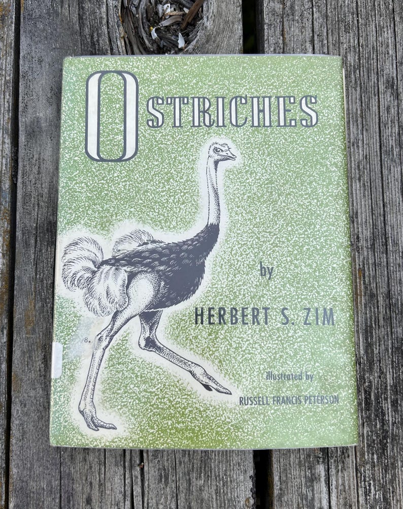 May include: A hardback book titled OSTRICHES by Herbert S. Zim, illustrated by Russell Francis Peterson. The cover features a green background with a white speckled pattern and a black and white line drawing of an ostrich in the centre.