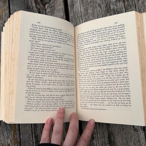 K&ouml;nnte beinhalten: Ein aufgeschlagenes Hardcover-Buch mit cremefarbenen Seiten und schwarzem Drucktext. Die linke Seite ist mit 402 und die rechte Seite mit 403 nummeriert. Das Buch ist mit sichtbarer Bindung und R&auml;ndern dargestellt und zeigt dichte Abs&auml;tze mit Erz&auml;hltext.