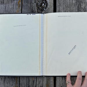 May include: An open book with cream-coloured pages featuring the text "Rahway School District No. 12 Library" printed at the top of both pages. The left page includes the handwritten text "Acc. No. 3639" and the right page has a black ink stamp.