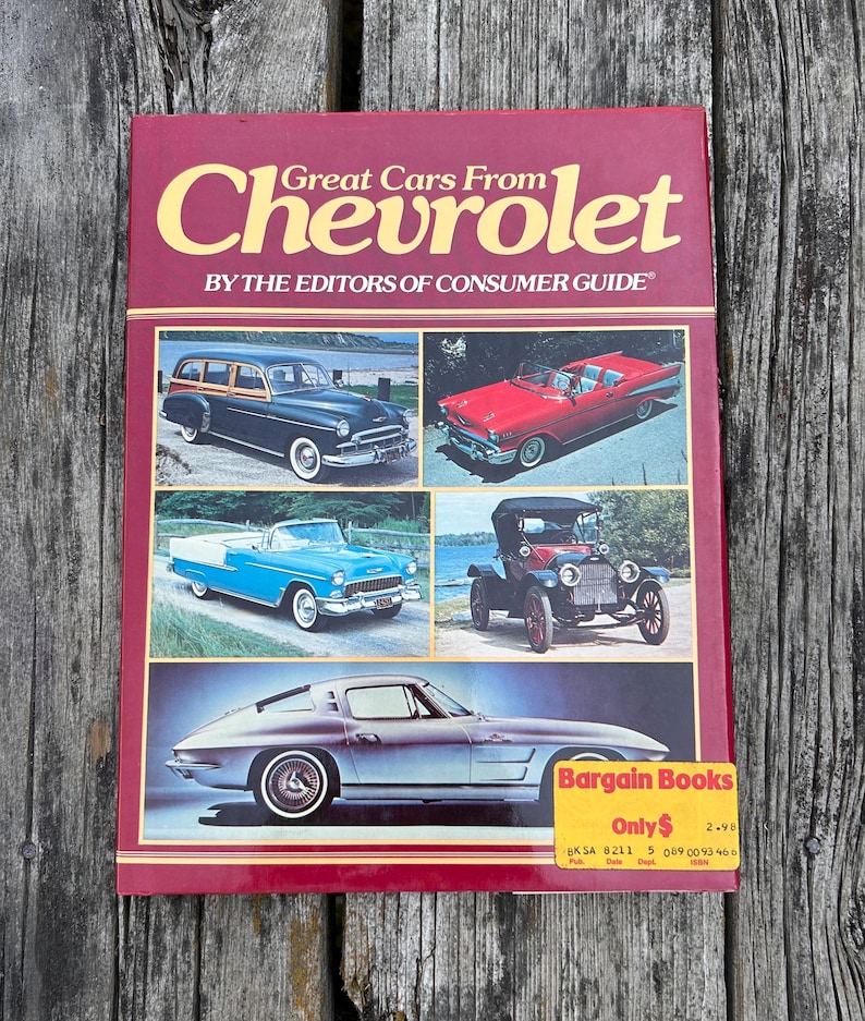 Op de afbeelding: Een paperbackboek getiteld Great Cars From Chevrolet door de redactie van Consumer Guide. De bordeauxrode omslag bevat vijf foto's van vintage Chevrolet-auto's en een gele Bargain Books-sticker in de rechterbenedenhoek.