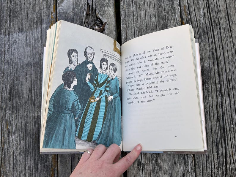 Puede incluir: Un libro de tapa dura abierto que muestra una p&aacute;gina con una ilustraci&oacute;n en blanco y negro de cuatro personas con ropa de &eacute;poca y una p&aacute;gina de texto impreso. El texto incluye las palabras: "Not in vain do we watch the setting and rising of the stars."