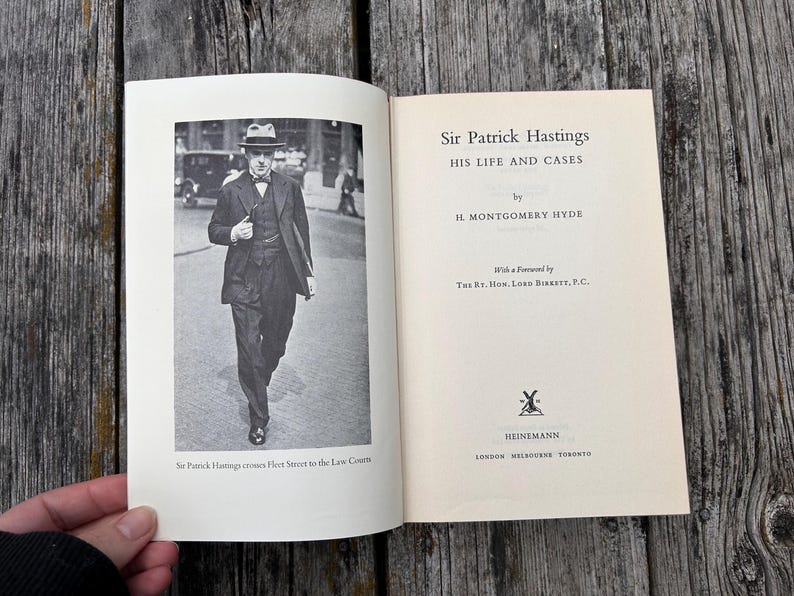 Pu&ograve; includere: Un libro con copertina rigida intitolato Sir Patrick Hastings: His Life and Cases di H. Montgomery Hyde. La pagina sinistra presenta una fotografia in bianco e nero di un uomo in abito e cappello che cammina, con la didascalia Sir Patrick Hastings.