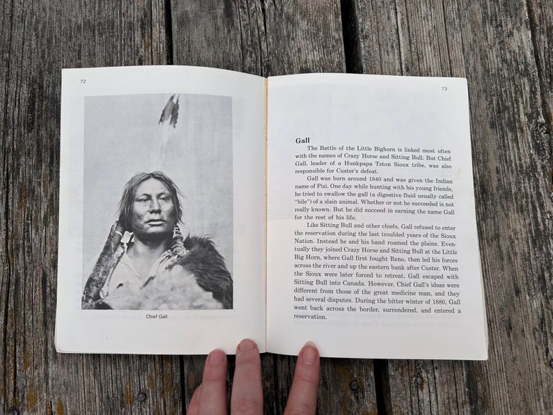 Może przedstawiać: Otwarta książka z dwiema stronami, przedstawiająca czarno-biały portret wodza Galla po lewej stronie oraz tekst biograficzny zatytułowany Gall po prawej stronie. Tekst opisuje historię przyw&oacute;dcy Hunkpapa Teton Sioux i jego rolę w bitwie nad Little Bighorn.