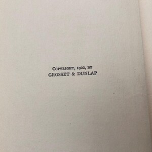 May include: A page from a book featuring the printed text COPYRIGHT, 1922, BY GROSSET & DUNLAP centered on the page. To the right, a partial list of chapters is visible, starting with the word CHAPTER followed by Roman numerals I through XII.