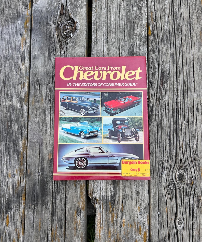 Op de afbeelding: Een rood paperbackboek met de titel Great Cars From Chevrolet by the Editors of Consumer Guide. De omslag bevat vijf foto's van vintage Chevrolet-voertuigen en een gele Bargain Books-sticker in de rechterbenedenhoek.