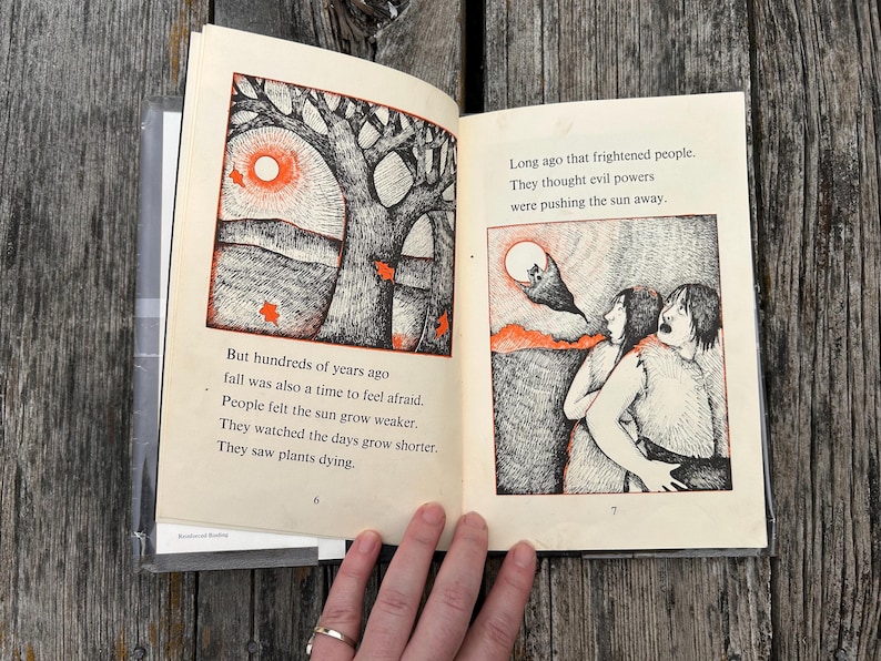 Może przedstawiać: Otwarta książka ze stronami 6 i 7 przedstawiająca czarno-białe ilustracje tuszem z pomarańczowymi akcentami. Tekst brzmi: But hundreds of years ago fall was also a time to feel afraid. People felt the sun grow weaker.