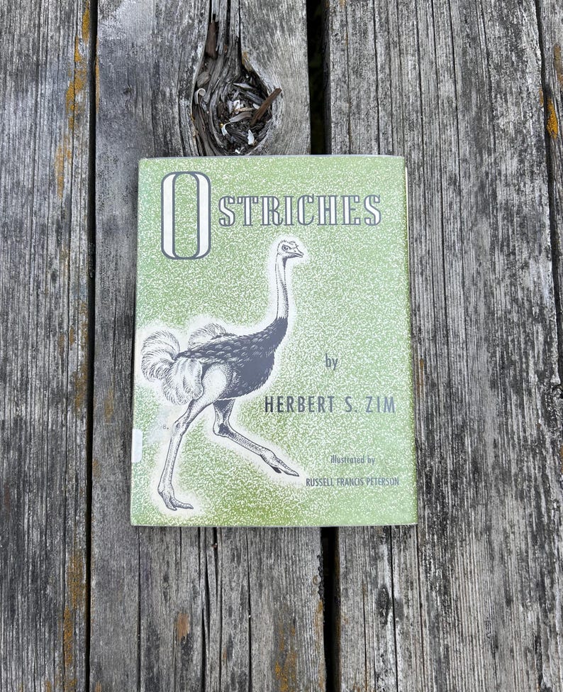 May include: A hardback book titled Ostriches by Herbert S. Zim, illustrated by Russell Francis Peterson. The cover is light green with a white speckled texture and features a black and white line drawing of an ostrich in the centre.