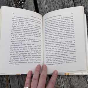 May include: An open hardcover book with white pages and black printed text. The left page is numbered 76 with the header The Story of Our Flag. The right page is numbered 77 with the header Fifteen Stars and Fifteen Stripes.