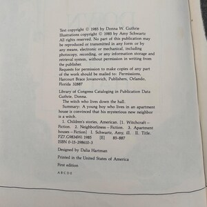 Puede incluir: Una p&aacute;gina de libro blanca con texto impreso en negro que incluye informaci&oacute;n de derechos de autor para el libro The Witch Who Lives Down the Hall de Donna W. Guthrie, ilustrado por Amy Schwartz, publicado en 1985, con datos de la biblioteca.