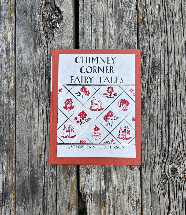 May include: A hardcover book titled Chimney Corner Fairy Tales by Veronica S. Hutchinson. The cover is orange with a white central panel featuring a black and red diamond pattern containing illustrations of castles, flowers, and royal figures.
