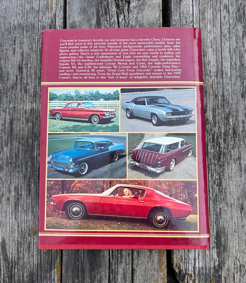 Op de afbeelding: Een hardcover boek getiteld Great Cars From Chevrolet met een dieprode kaft. De achterkant bevat een beschrijvende tekst over de geschiedenis van Chevrolet en vijf kleurenfoto's van oldtimers, waaronder een rode coup&eacute; en een stationwagen.