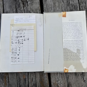 May include: An open hardcover book with a library checkout card and pocket attached to the left page. The right page features a printed biography titled The Authors. The text includes details about Carl Glick and Ollie Rogers.