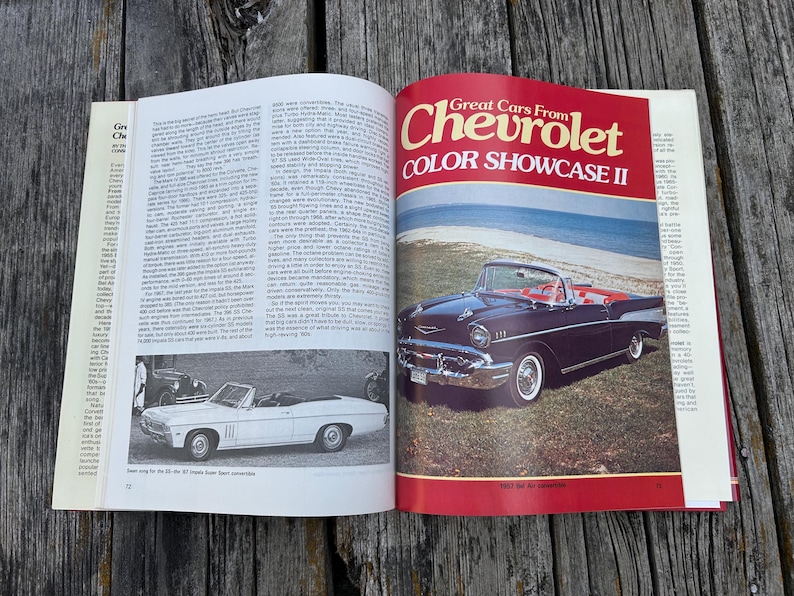 Op de afbeelding: Een open boek met de titel Great Cars From Chevrolet COLOR SHOWCASE II. De pagina toont een donkerblauwe cabriolet geparkeerd bij een strand, met een kleinere zwart-witfoto van een witte cabriolet op de linkerpagina.