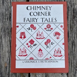 May include: A hardcover book titled Chimney Corner Fairy Tales by Veronica S. Hutchinson. The cover features a white background with a red diamond grid pattern containing illustrations of castles, flowers, and figures, framed by a red border.