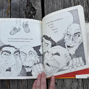 May include: An open book with black and white illustrations of four grotesque, monstrous figures with large noses and sharp teeth. The text reads: An' they snatched her through the ceilin' 'fore she knew what she's about! An' the Gobble-uns'll git you EF YOU DON'T WATCH OUT!