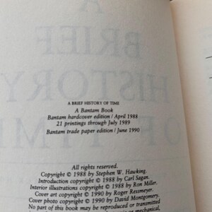 Peut inclure: Page ouverte d'un livre avec le texte de "Une br&egrave;ve histoire du temps" de Stephen Hawking. D&eacute;tails incluant le titre, l'&eacute;diteur et les informations de copyright. Le texte est en noir sur une page cr&egrave;me.