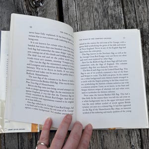 May include: An open hardcover book with white pages and black printed text. The left page is numbered 30 and titled The Story of Old Glory, while the right page is numbered 31 and titled The Flags of the Thirteen Colonies.