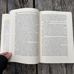May include: An open paperback book with white pages and black printed text. The book is displayed with two facing pages visible, featuring multiple paragraphs of narrative content. The page numbers 68 and 69 are printed at the bottom corners.