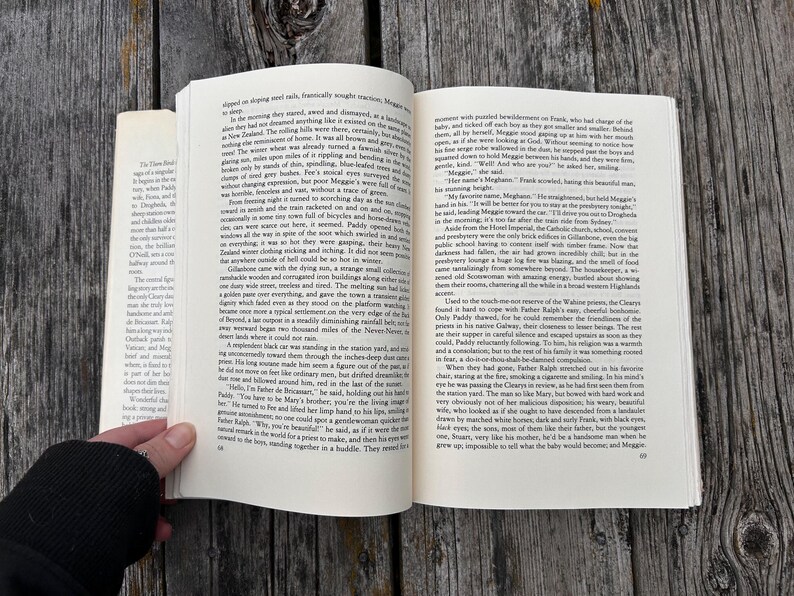 May include: An open paperback book with white pages and black printed text. The book is displayed with two facing pages visible, featuring multiple paragraphs of narrative content. The page numbers 68 and 69 are printed at the bottom corners.