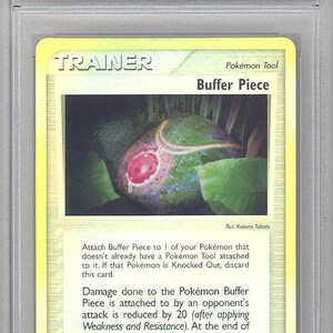 May include: A 2003 Pokemon EX Buffer Piece trading card, number 83, graded EX-MT 6 by PSA. The card features a yellow border, the text 'Trainer' and 'Buffer Piece', and an illustration of a pink gem pendant resting on green leaves.