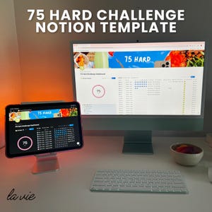 May include: A workspace setup featuring a desktop computer and a tablet displaying a "75 Hard Challenge Notion Template." The computer and tablet screens show a dashboard with progress tracking. A white keyboard and a small bowl are also visible.