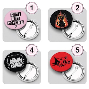 Könnte beinhalten: Sechs 25 mm große Anstecknadeln mit verschiedenen Designs. Die erste Nadel ist pink mit schwarzem Text, der "Cute but Psycho" mit einem kleinen rosa Herz sagt. Die zweite Nadel ist schwarz mit einer schwarzen Katze in Flammen. Die dritte Nadel ist lila mit goldenem Text, der "Crazy AF" sagt. Die vierte Nadel ist schwarz mit einer Schwarzweißillustration einer Frau mit einem teuflischen Ausdruck. Die fünfte Nadel ist rot mit einer Schwarzweißillustration einer Katze mit einem teuflischen Ausdruck. Die sechste Nadel ist schwarz mit einer Schwarzweißillustration einer Katze mit einem teuflischen Ausdruck.