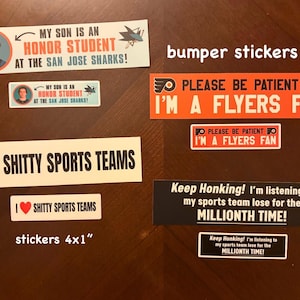 Könnte beinhalten: Eine Sammlung rechteckiger Aufkleber mit sportbezogenen Texten. Die Designs umfassen My Son Is An Honor Student At The San Jose Sharks, Please Be Patient I'm A Flyers Fan, I Heart Shitty Sports Teams und Keep Honking! I'm listening to my sports team lose for the millionth time. Die Maße 20,32x5,08 cm und 10,16x2,54 cm sind auf dem Bild aufgedruckt.