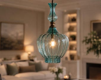 May include: A hanging pendant light featuring a translucent teal glass shade with a vertical ribbed texture. The fixture has a slender, elongated neck and a wider, rounded base, connected to a brass-toned metal fitting and a single light bulb.