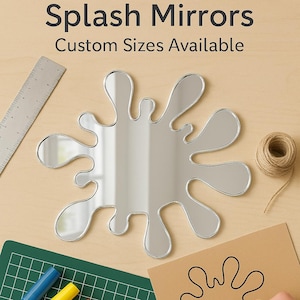 Pode incluir: Um espelho em forma de respingo com uma superfície reflexiva. A imagem inclui uma régua, marcadores, tesouras e um desenho da forma do espelho. O texto diz "Splash Mirrors" e "Custom Sizes Available."