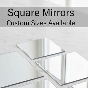 May include: A collection of square mirrors in various sizes, reflecting the surrounding environment. The mirrors are arranged on a white marble surface. Text at the top reads "Square Mirrors Custom Sizes Available."