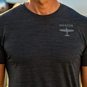 May include: A dark grey t-shirt with a small airplane graphic and the text "N44836" printed on the front.