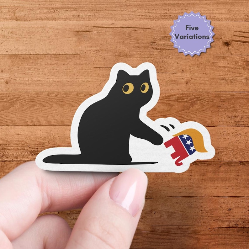 Puede incluir: Una pegatina de gato negro con ojos amarillos, golpeando una representaci&oacute;n de dibujos animados de una figura pol&iacute;tica. La figura se muestra con colores rojo, blanco y azul. Una pegatina morada con el texto "Five Variations" est&aacute; en el fondo.