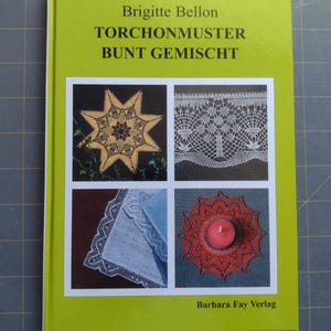 May include: A book with a bright green cover featuring the title "TORCHONMUSTER BUNT GEMISCHT" and the author's name, Brigitte Bellon. The cover displays four images of lace designs, including a star, a lace curtain, a handkerchief, and a red doily with a candle.