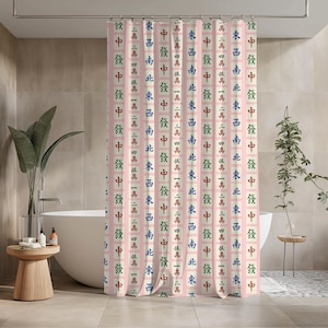 May include: A pink shower curtain with a repeating pattern of Chinese characters in red, green, blue, and black. The curtain is hanging in a bathroom with a white bathtub and wooden side table.