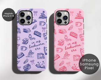 May include: Two phone cases with a bookworm theme. One is lavender, the other is pink. Both cases feature a repeating pattern of books, coffee cups, feathers, and the text "in my bookworm era."