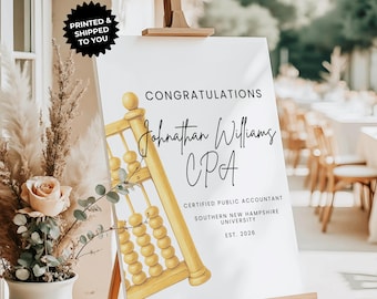May include: A white graduation sign on an easel with the text "CONGRATULATIONS" and "Johnathan Williams CPA". It features a watercolor illustration of an abacus and the text "CERTIFIED PUBLIC ACCOUNTANT".