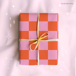 May include: A present wrapped in pink and orange chequered paper, tied with a cream ribbon. The gift is rectangular. The text "Horde Mentality" is visible in the top right corner.