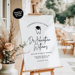 May include: A white graduation sign on an easel with the text "Congratulations Dr. Johnathan Williams, Doctor of Dental Surgery, Harvard School of Dental Medicine, Class of 202X." A black mortarboard and tooth graphic is at the top.
