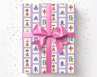 May include: A wrapped gift with a light purple background featuring a pattern of Mahjong tiles in various colors. The gift is tied with a pink ribbon and bow. The text "Horde Mentality" is in the upper right corner.