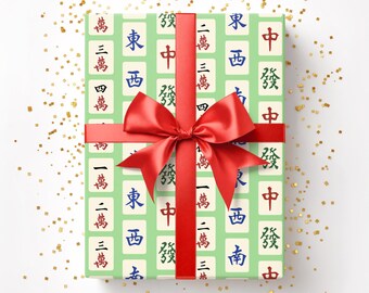 May include: A gift wrapped in light green paper with a pattern of Mahjong tiles, tied with a red ribbon and bow. The text "Horde Mentality" is in the upper right corner. Gold confetti is scattered around the gift.