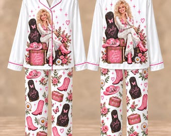 May include: A white pajama set with pink piping featuring a graphic of Dolly Parton sitting on luggage with a guitar case, cowboy hat, and flowers. The pattern includes repeating motifs of pink cowboy boots, guitar cases, and floral arrangements.