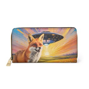 Cartera con cremallera con un zorro rojo en un campo bajo un OVNI durante una puesta de sol colorida, divertido monedero de arte pop de ciencia ficción