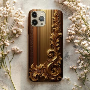 May include: A phone case with a gold and brown design. The case has a vertical striped pattern with a detailed gold floral embellishment on the side. White flowers surround the case.