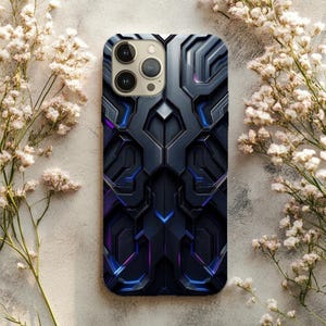 Puede incluir: Una funda de teléfono inteligente con un diseño geométrico en tonos negro, gris y azul. La funda tiene una apariencia texturizada con patrones intrincados y un acabado brillante. Flores blancas rodean la funda.