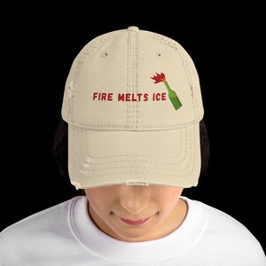 May include: A trio of cream-glazed ceramic mugs, each adorned with a hand-painted floral pattern in blue, green, and yellow. The mugs have a rounded form and a handle, ideal for tea or coffee. The speckled glaze adds a rustic charm.