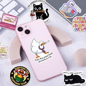 a collection of various stickers and illustrations, including a pink phone case with a cartoon duck holding a knife, a skeleton with a cup, and other whimsical and humorous designs.