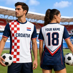 A man and a woman are standing on a soccer field, holding soccer balls. The man is wearing a white and red jersey with the word "Cratia" on it, and the woman is wearing a blue jersey with the number 18 on it.